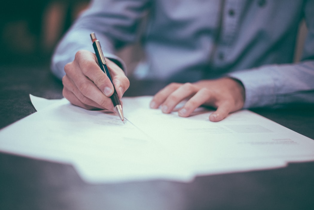 image of man signing paper